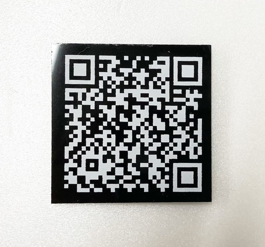 黒いプラスチックプレートに白でQRコードの印刷