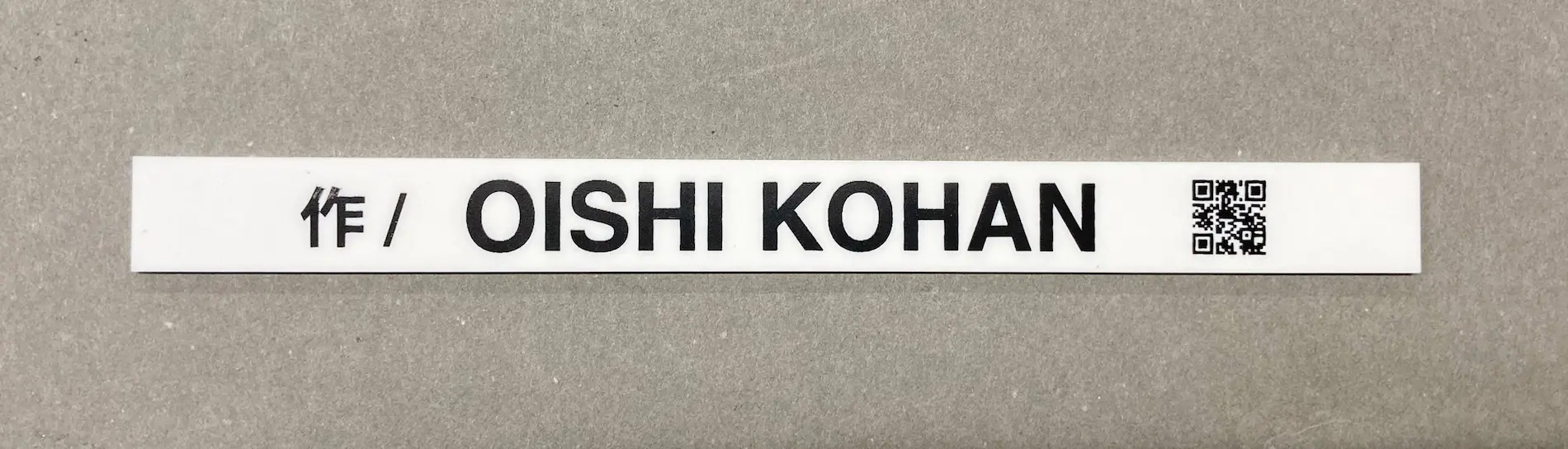 白いアクリル板にオリジナルの文字を印刷して展示プレートの作者の表示