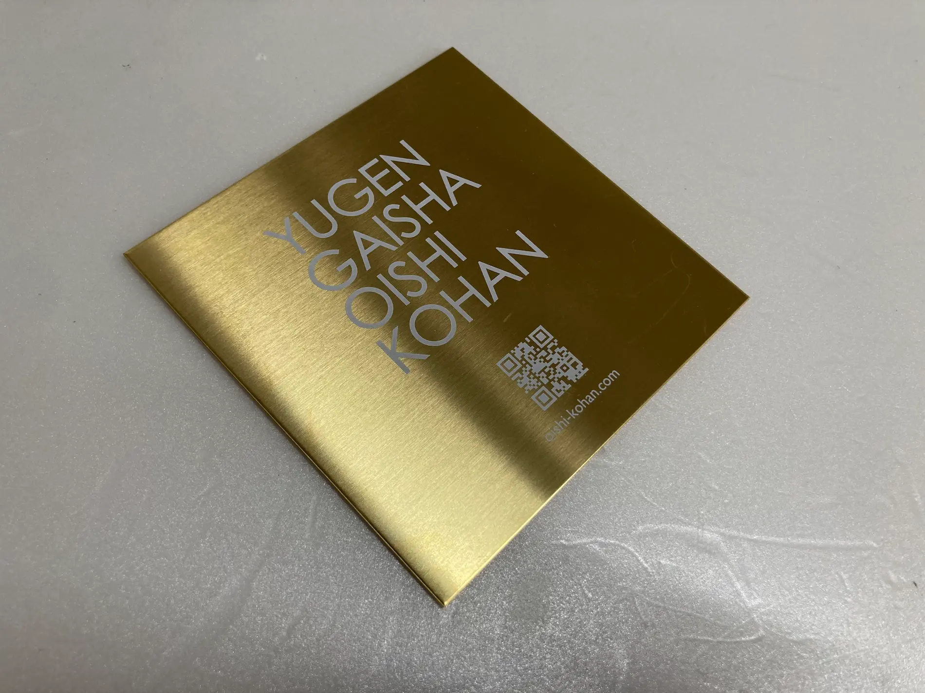 金の金属プレートに白でQRコードを印刷